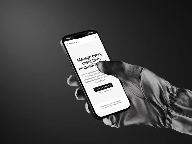 A gloved hand holding a phone against a black background, showing the Client Paper Co. app used to chase an unpaid invoice
