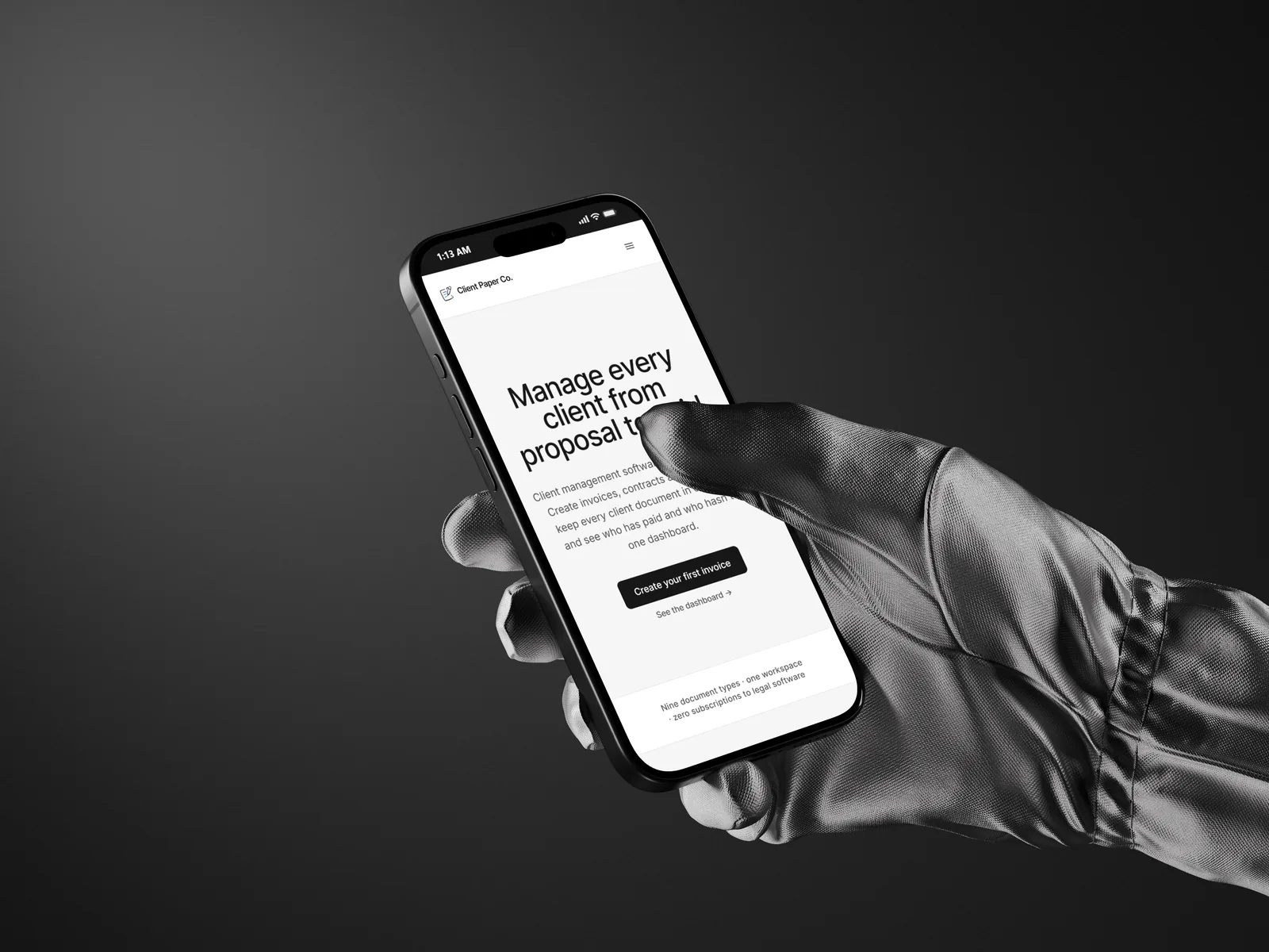 A gloved hand holding a phone against a black background, showing the Client Paper Co. app used to chase an unpaid invoice